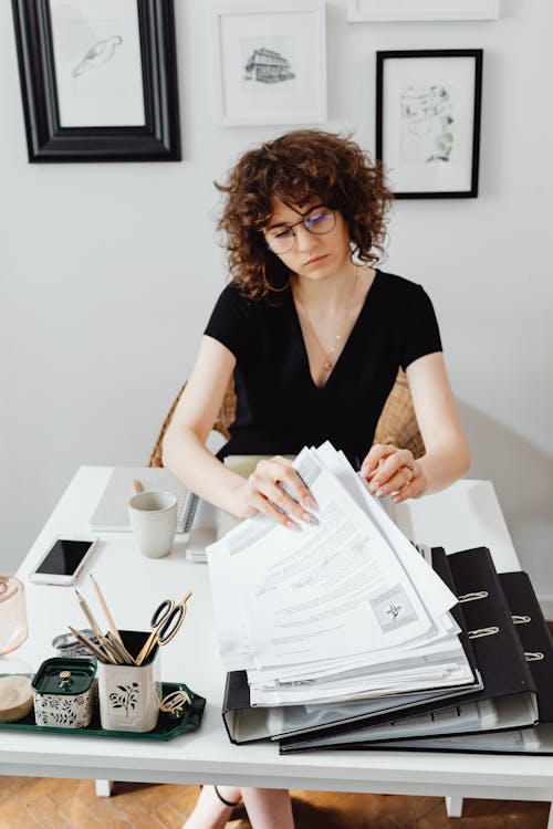 Free Photo of a Woman in Looking at Papers Stock Photo