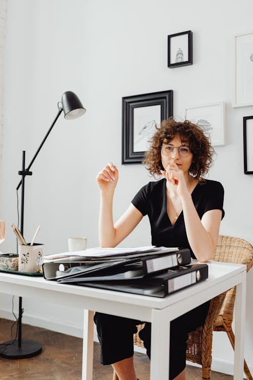 Woman in a Black Shirt Working on Her Table