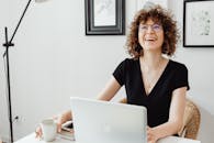 Woman in Black V Neck Shirt Wearing Eyeglasses Using Macbook