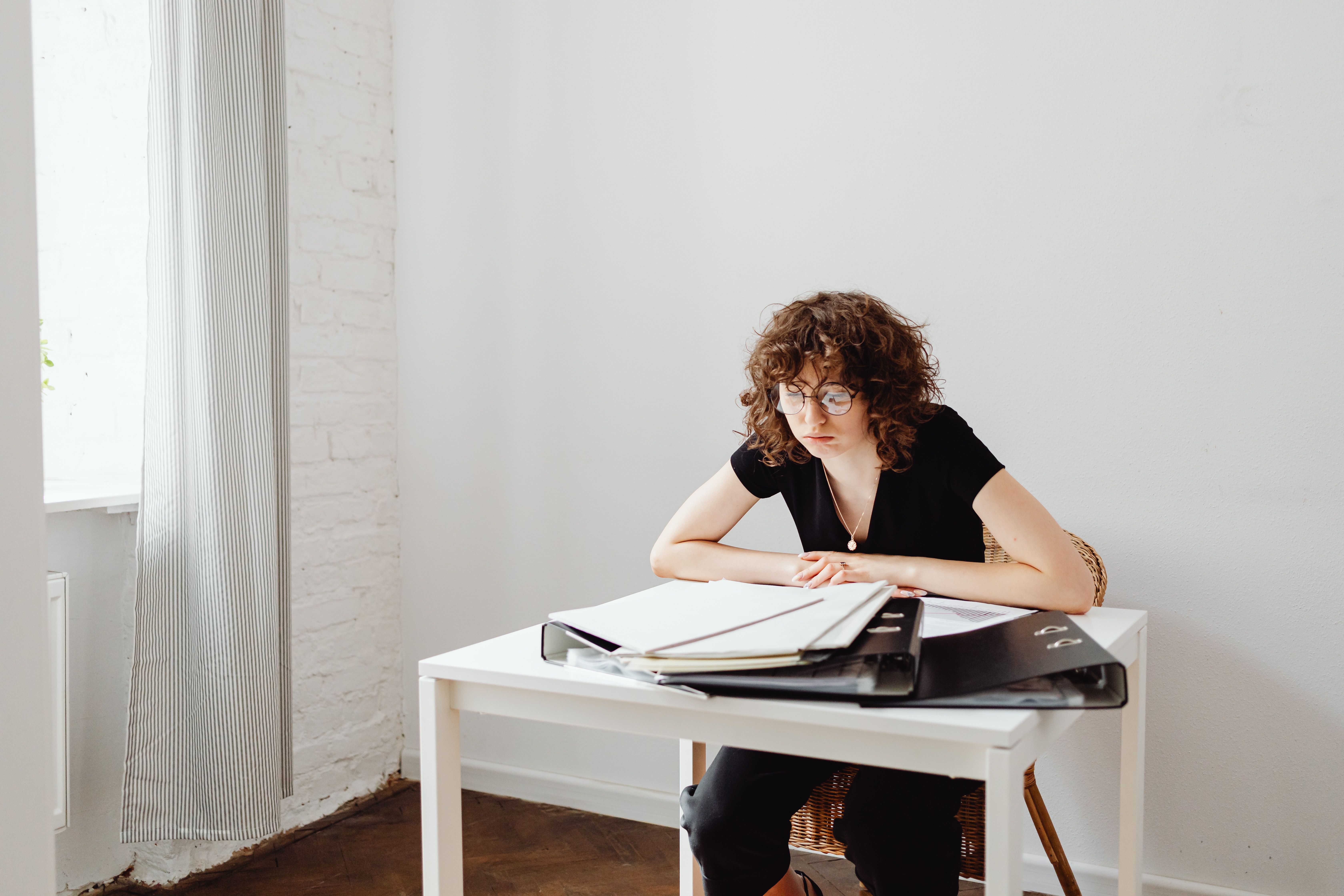 A young professional sitting at a desk with a clear boundary line drawn in the sand, looking relaxed and unbothered