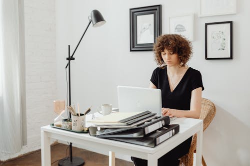 Free A Woman with Curly Hair Using a Laptop Stock Photo
