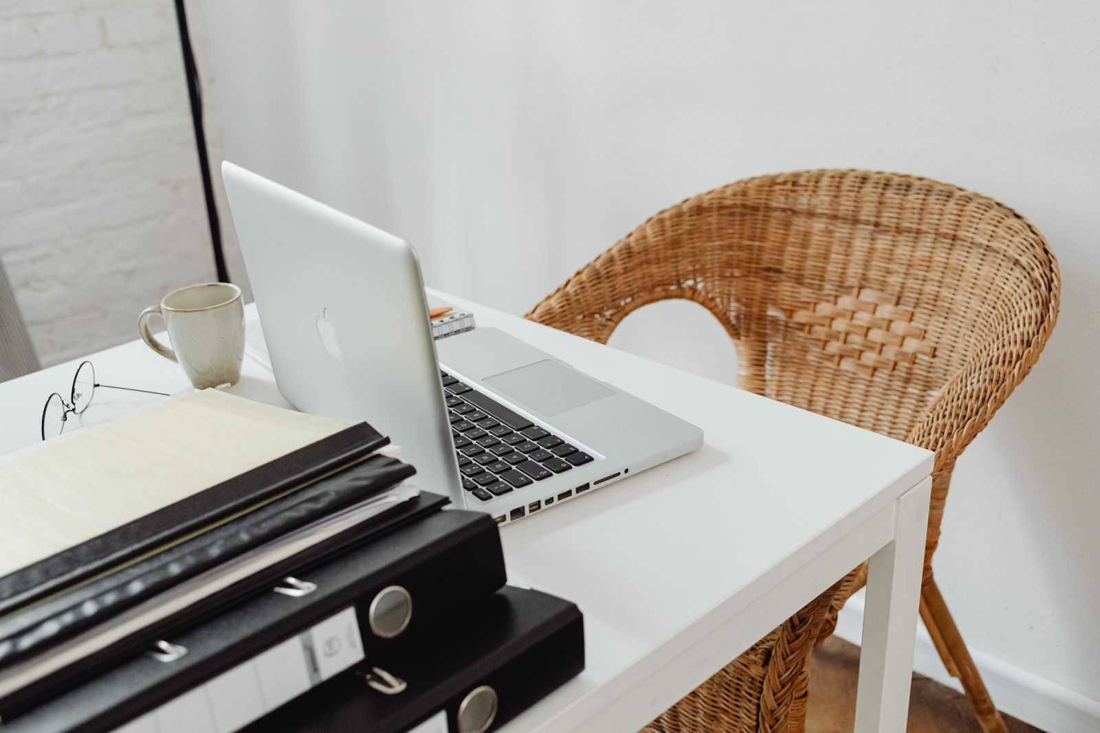 A small office desk with a laptop and binders, set up for daily business work