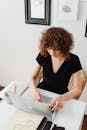 Woman in Black V Neck Shirt Sitting on White Chair