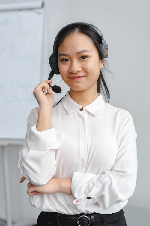 Woman in a White Shirt Wearing a Headset