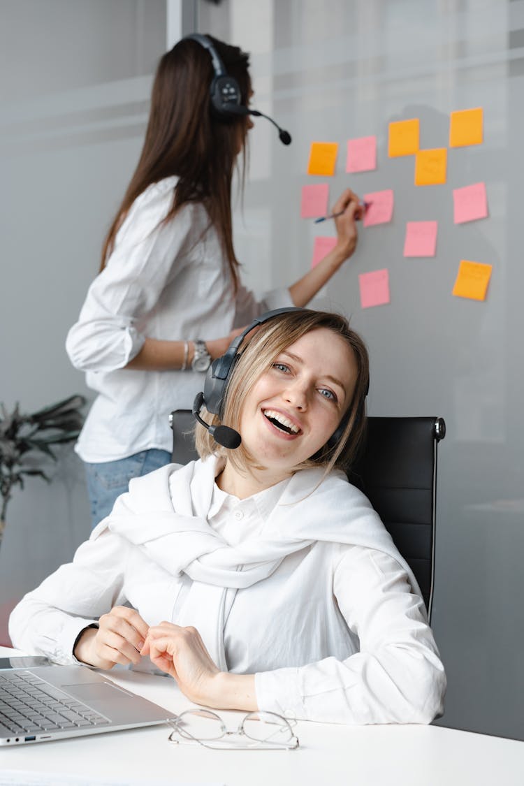 Smiling Woman In White Long Sleeve Shirt Working As A Call Center Agent