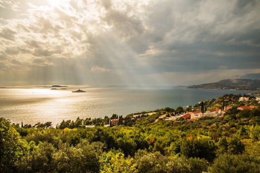 克罗地亚的亚得里亚海海岸线令人惊叹，郁郁葱葱的景观上，云层和阳光交相辉映，充满戏剧性