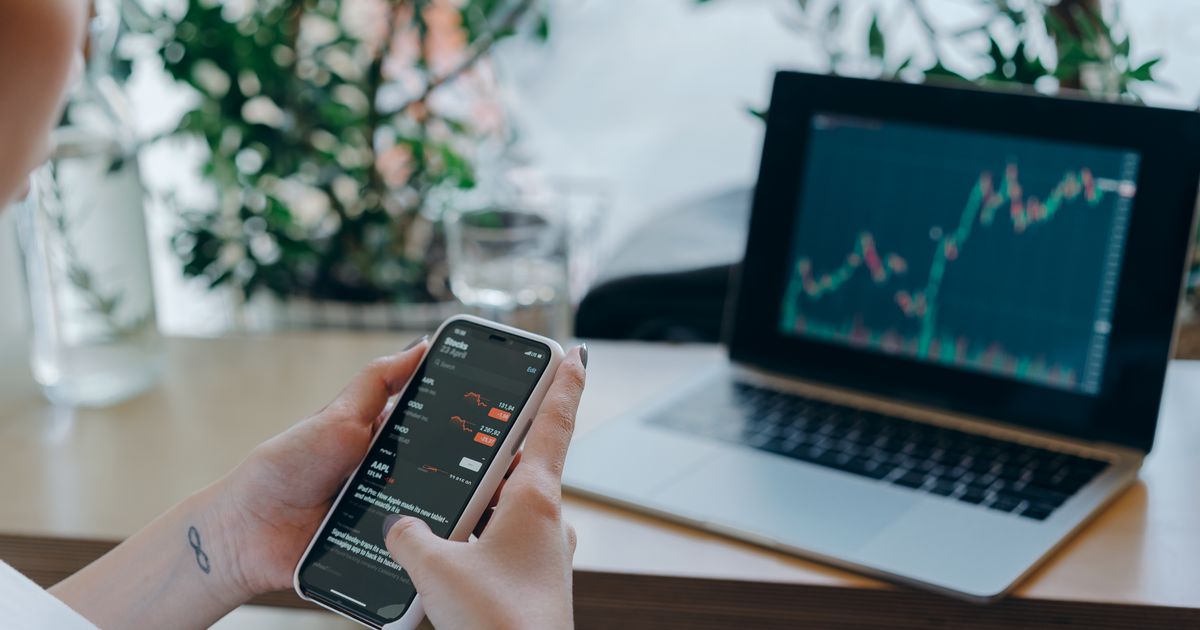 Person checking a trading account on a smartphone used to illustrate is forex trading halal