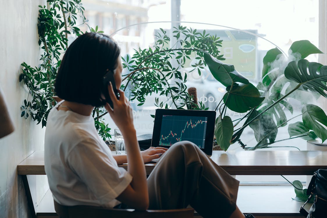 Businesswoman in White Shirt Sitting on Chair while Having Phone Call