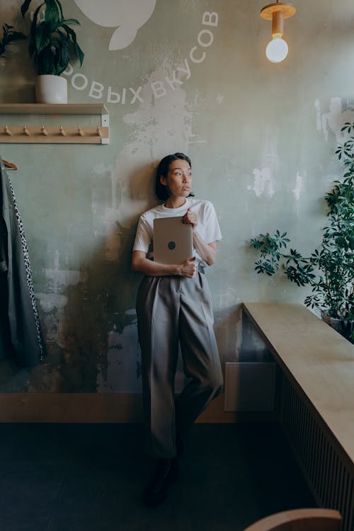 Free Woman in a White Shirt Holding a Laptop Stock Photo