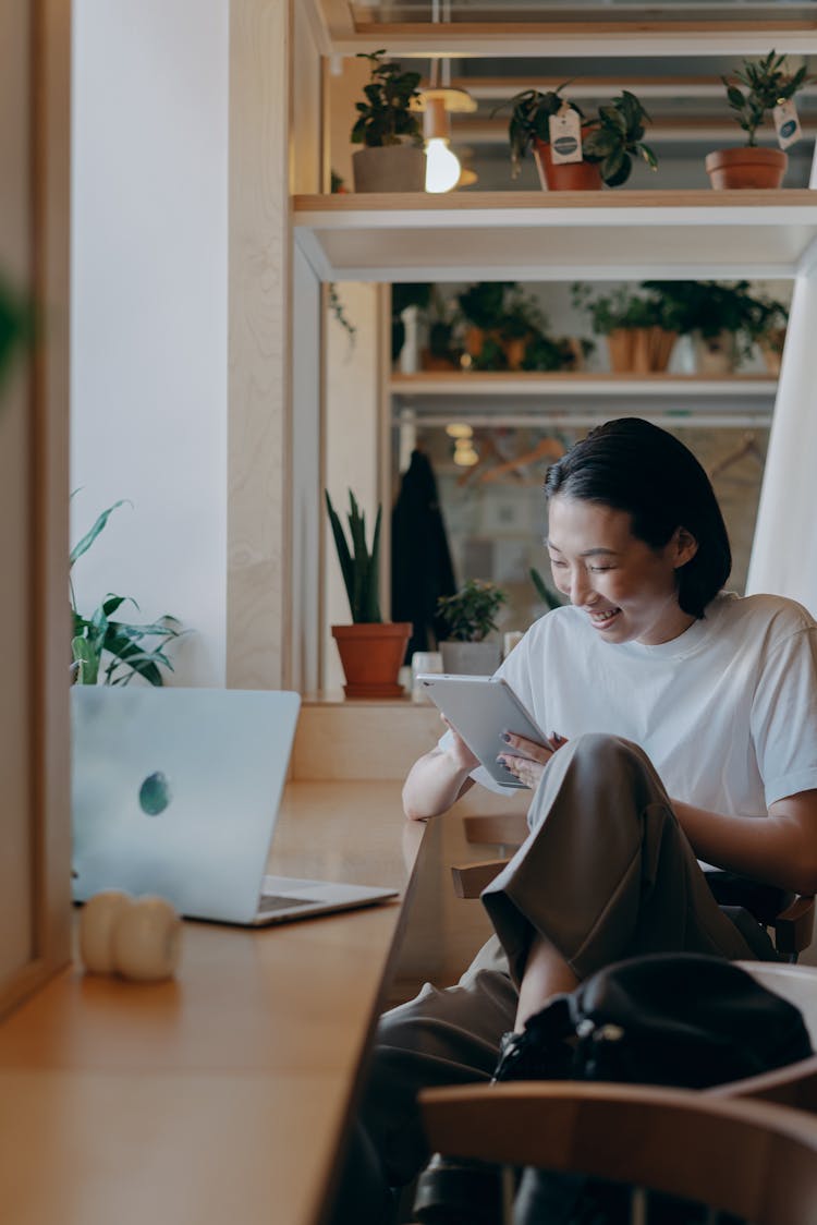 Smiling Businesswoman In White Shirt Using Her Tablet Computer