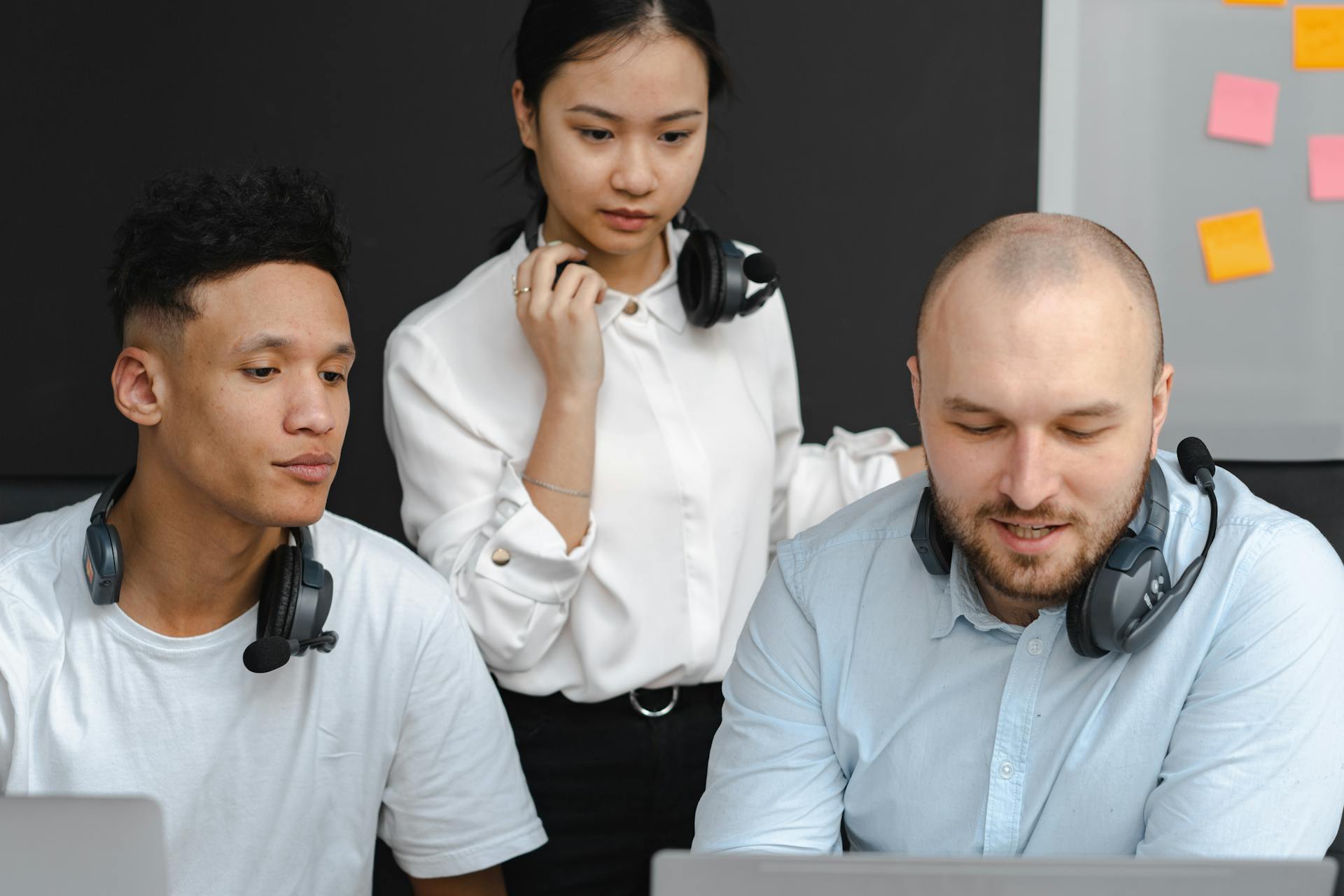 A diverse group of professionals collaborating in an office environment, using headsets for effective communication.