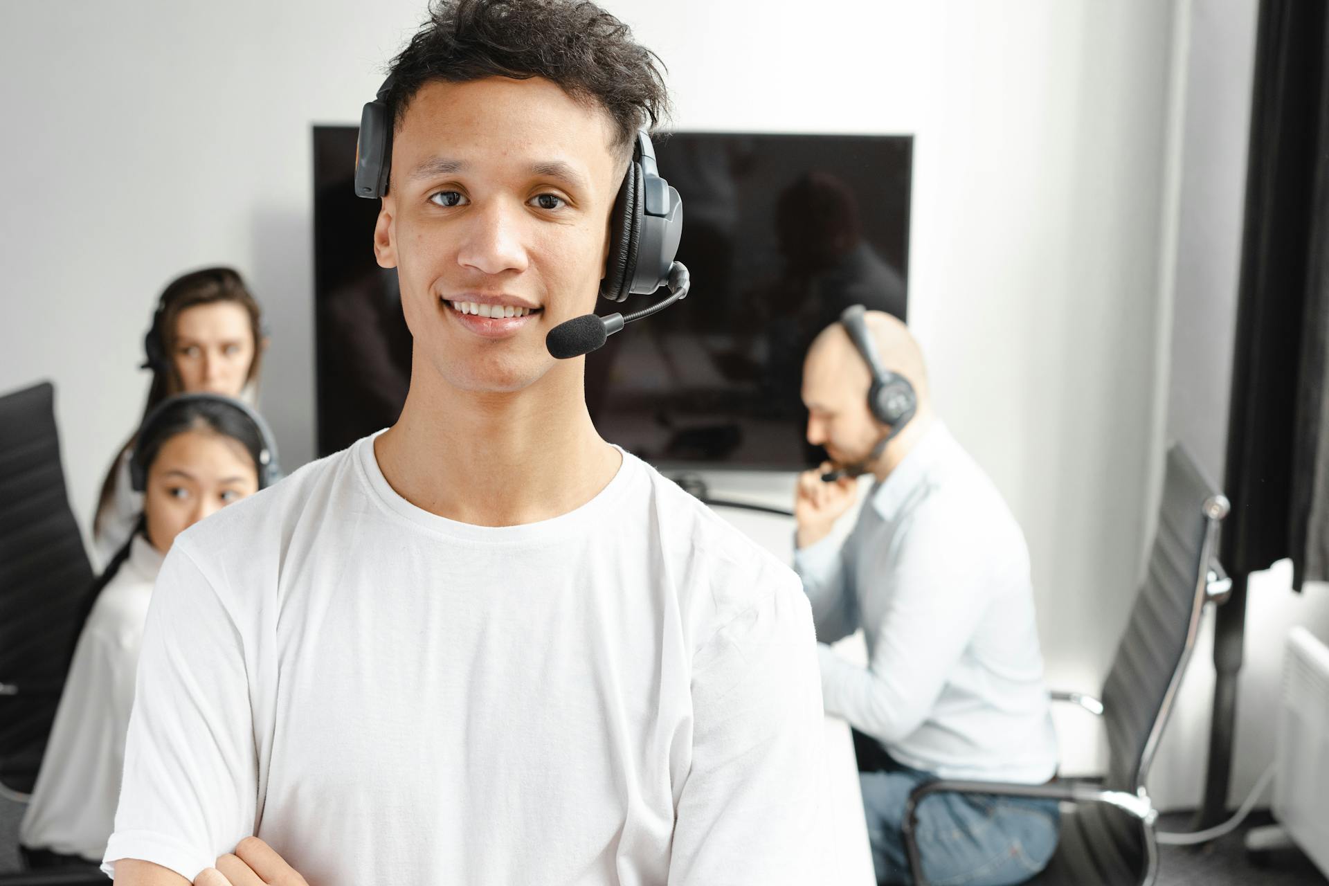 Smiling agents with headsets working in a bright, modern office environment.