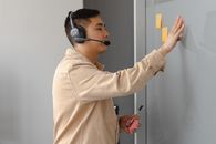 Man in Brown Long Sleeve Shirt Wearing Black Headphones