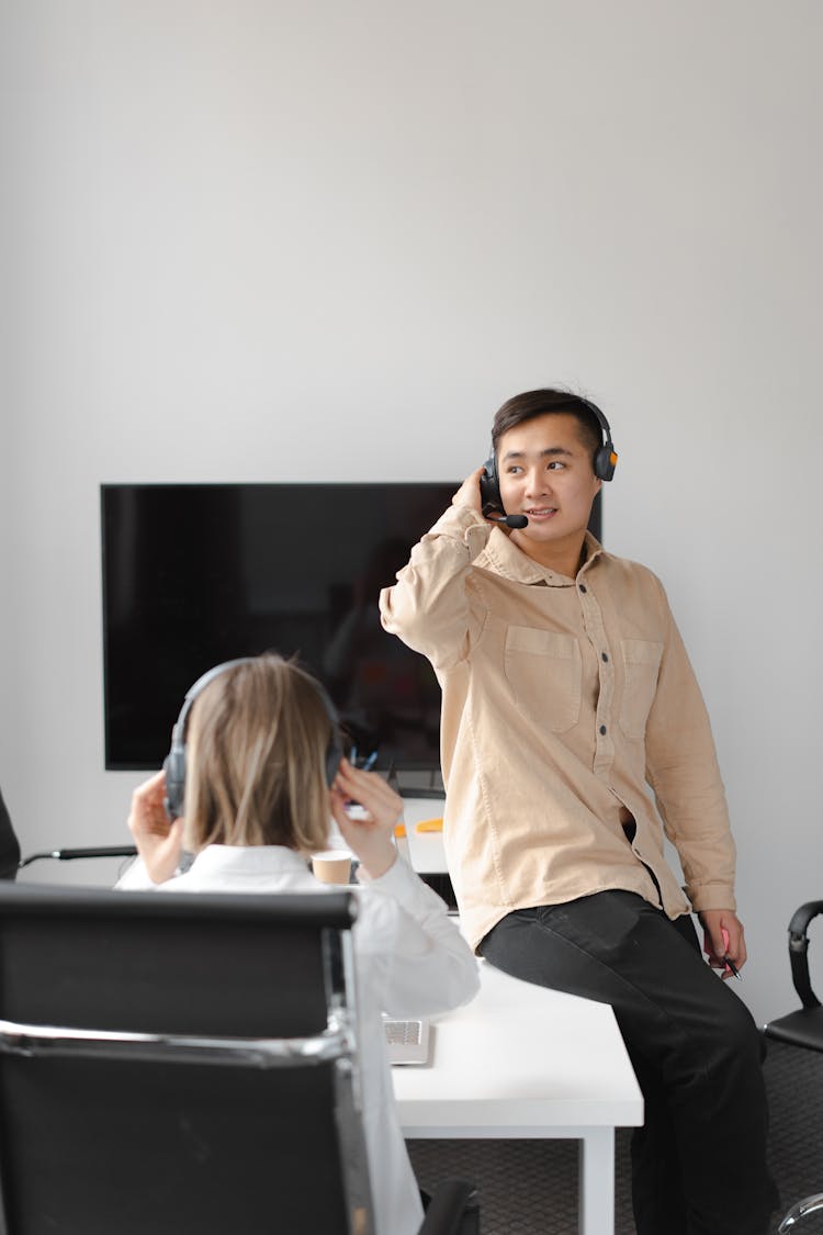 Man With A Headset Working While Sitting On A Table