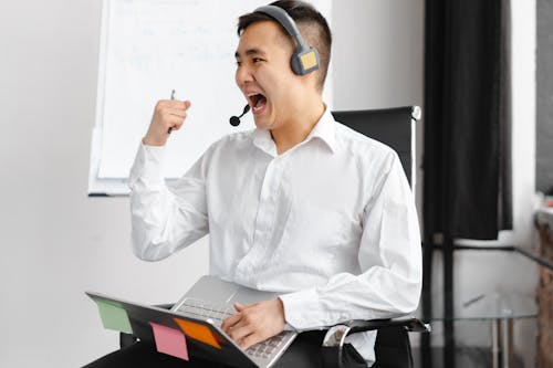 Man in White Dress Shirt Wearing Headphones