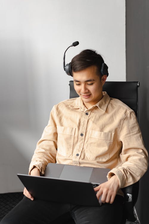 Man in Brown Dress Shirt Sitting on Black Chair