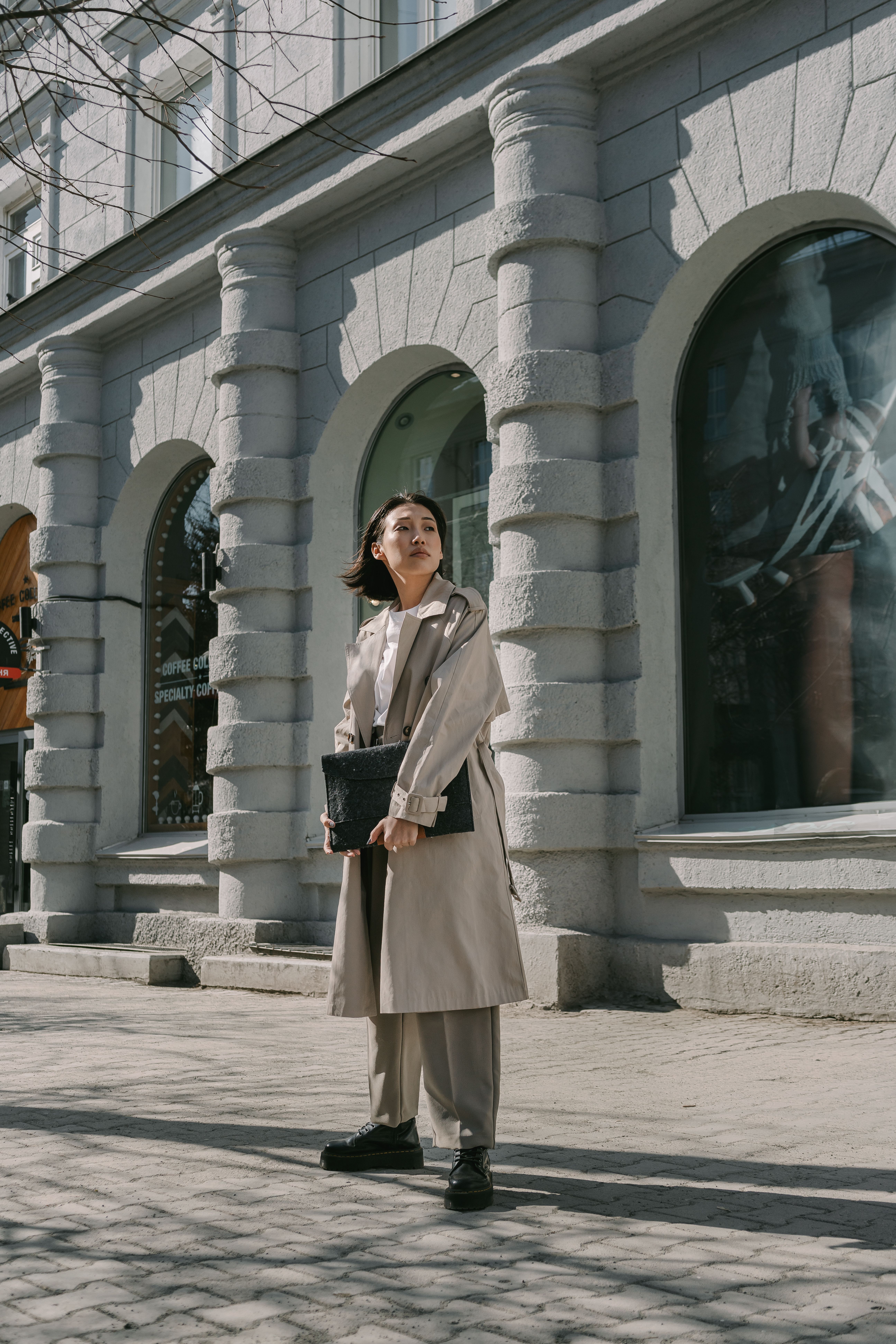 A Woman in Brown Coat Standing Near Building · Free Stock Photo
