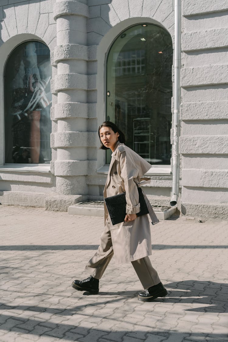 A Woman In Brown Coat Walking On The Street