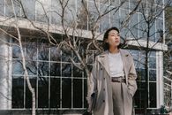 Woman in White Coat Standing Near Bare Trees