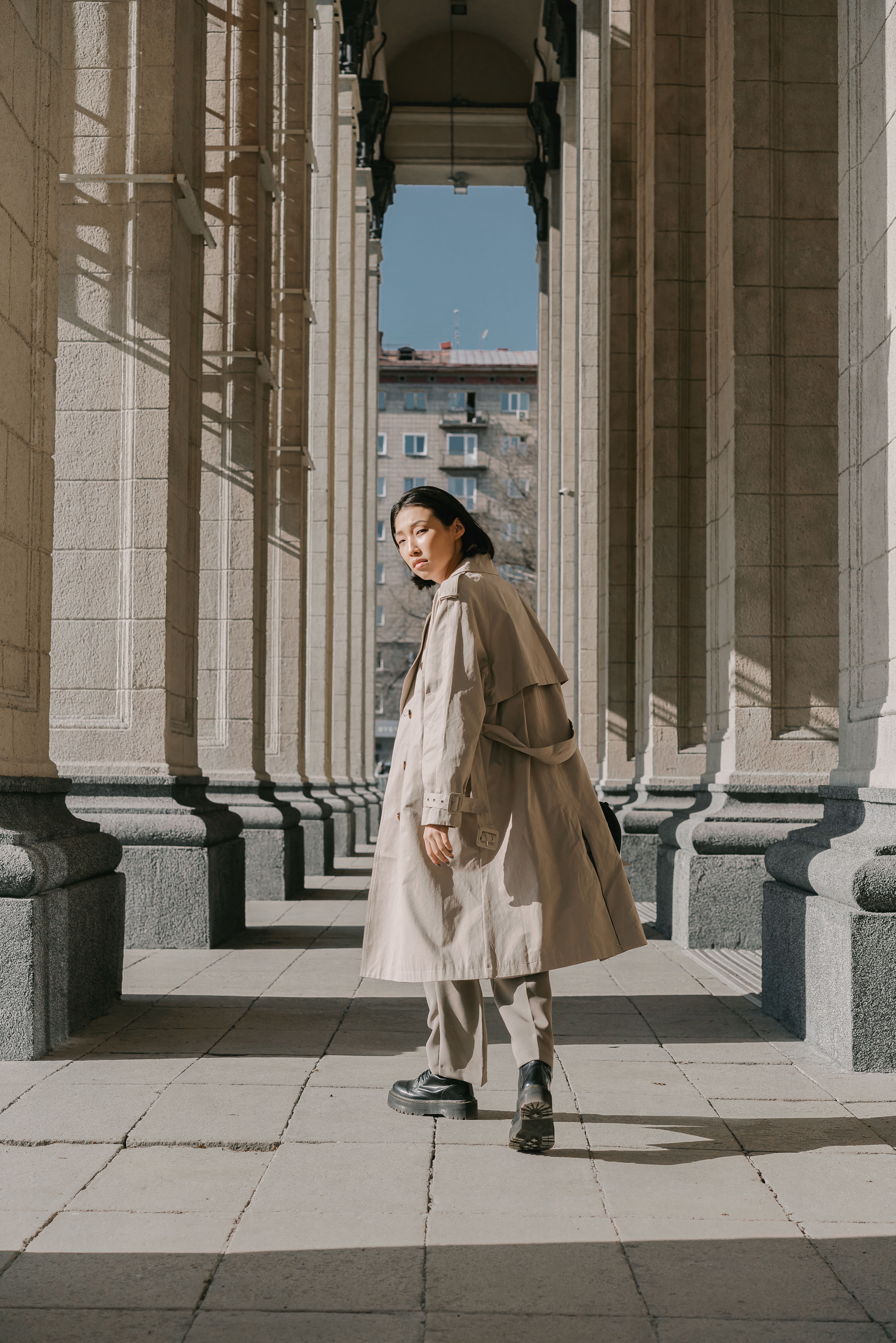 woman in trench coat with wide-leg trousers and loafers
