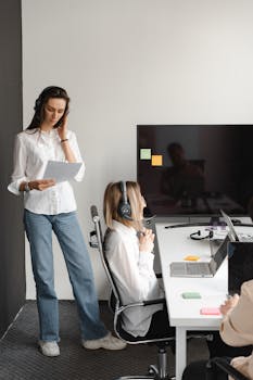 Professional women working together in a call center office environment, fostering communication and teamwork.