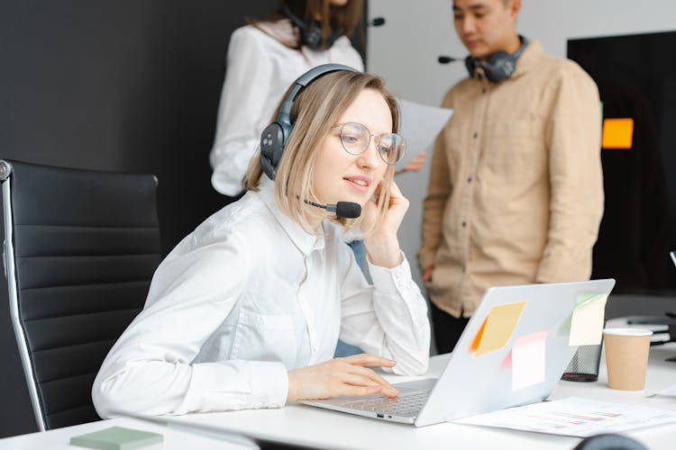 Woman With A Black Headset Working On Her Laptop