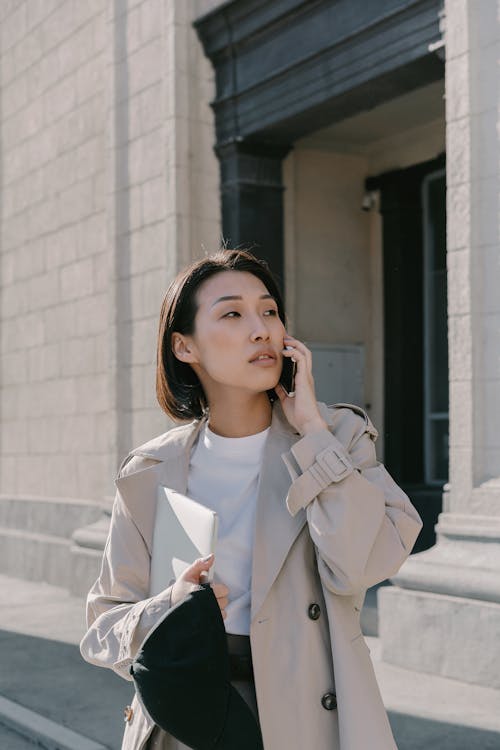 Woman in Trench Coat Having a Phone Call