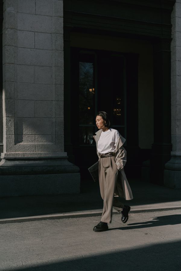 Woman in camel coat with white t-shirt and trousers
