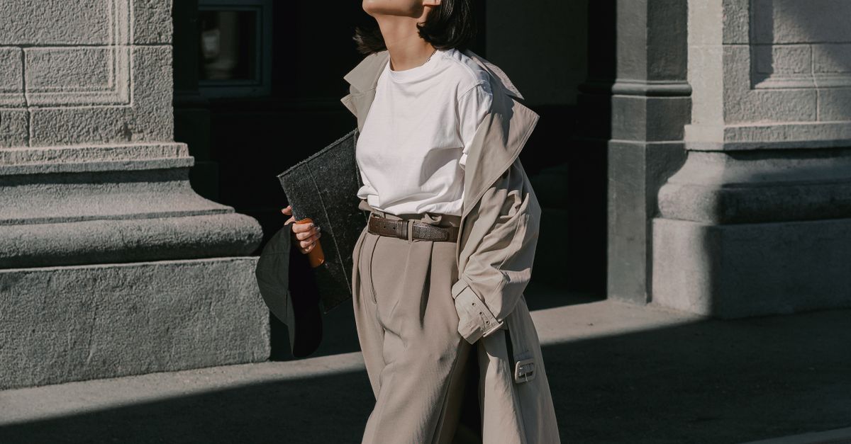 Woman in white tee, jeans and trench coat