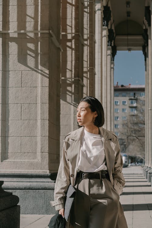 Woman in Beige Trench Coat Looking to Her Right