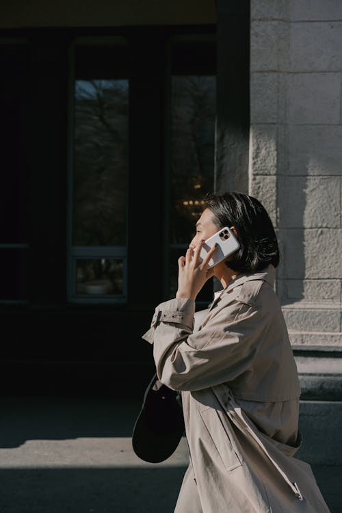 Woman in Beige Trench Coat Having a Phone Call