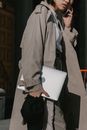 Person in Brown Coat Holding White Printer Paper