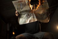 Shallow Focus of a Person Holding a Burning Newspaper