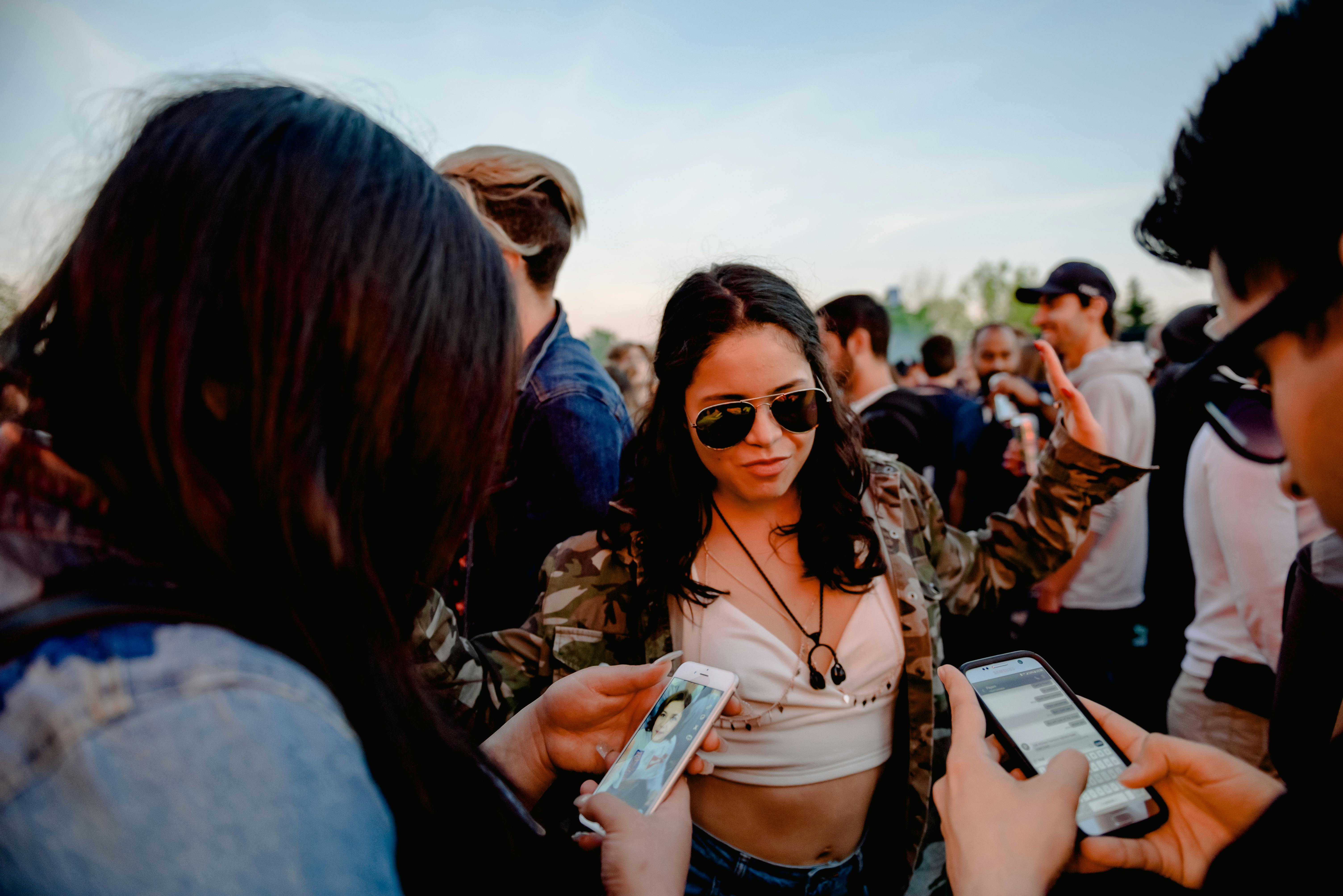 A lively outdoor event with people interacting on smartphones, capturing the essence of social connection.