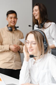 Friendly customer support team communicating in a modern office environment, using headsets.