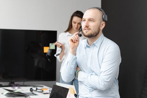 Shallow Focus Photo of Man in Blue Long Sleeves Working in a Call Center