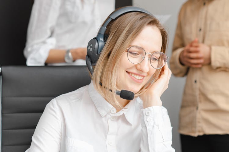 Woman In White Long Sleeves Using A Headphone