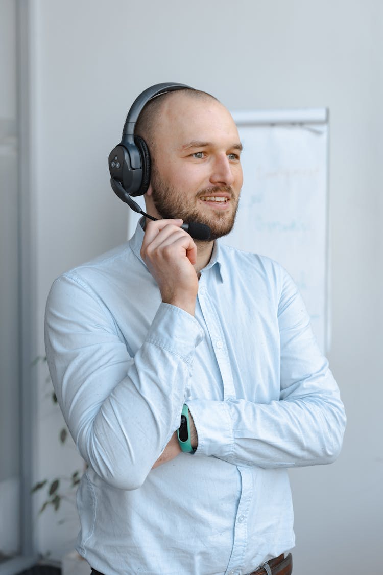 Smiling Man In Blue Long Sleeves Wearing A Black Headset