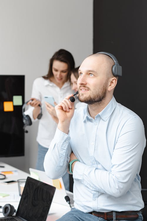 Free Shallow Focus Photo of Man in Blue Long Sleeves Working in a Call Center Stock Photo