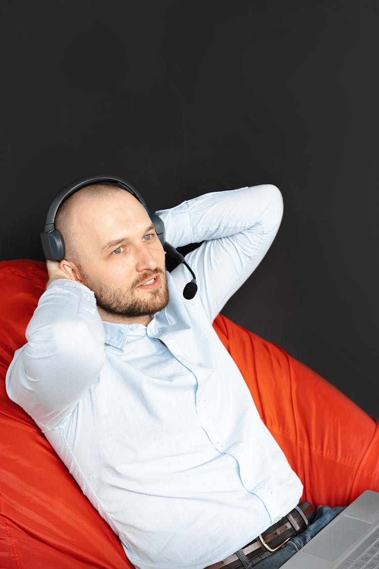 Man With A Black Headset Lying On A Red Surface