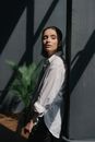 Woman in a White Shirt Leaning on a Gray Surface