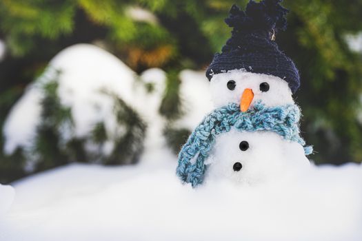 Adorable snowman with hat and scarf in a snowy outdoor setting, creating a festive winter scene.