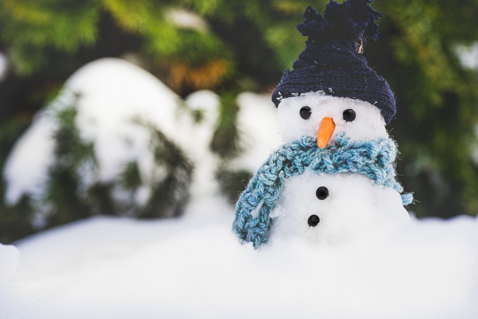 Adorable snowman with hat and scarf in a snowy outdoor setting, creating a festive winter scene.