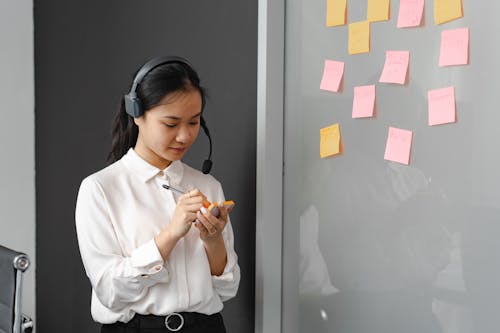 Woman Writing on a Sticky Note