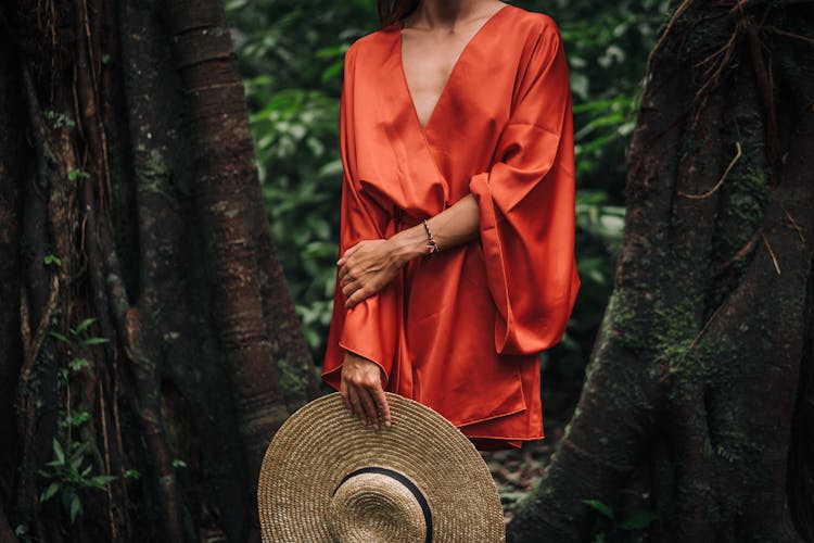 A Woman In Red Silk Robe Holding A Weave Hat