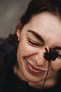 Lady with closed eyes with flowers near face
