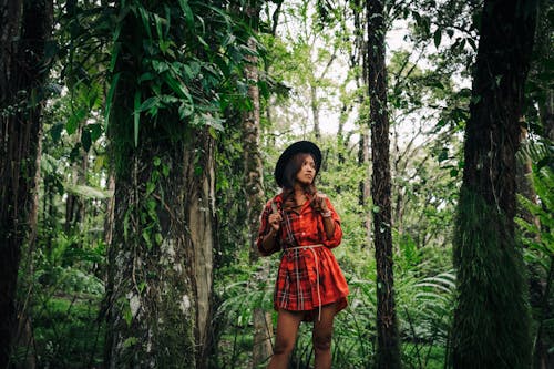 A Woman in Red Dress Standing in the Middle of the Rainforest