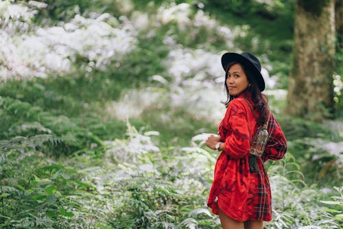 Free Woman Looking Back While Walking in the Forest Stock Photo