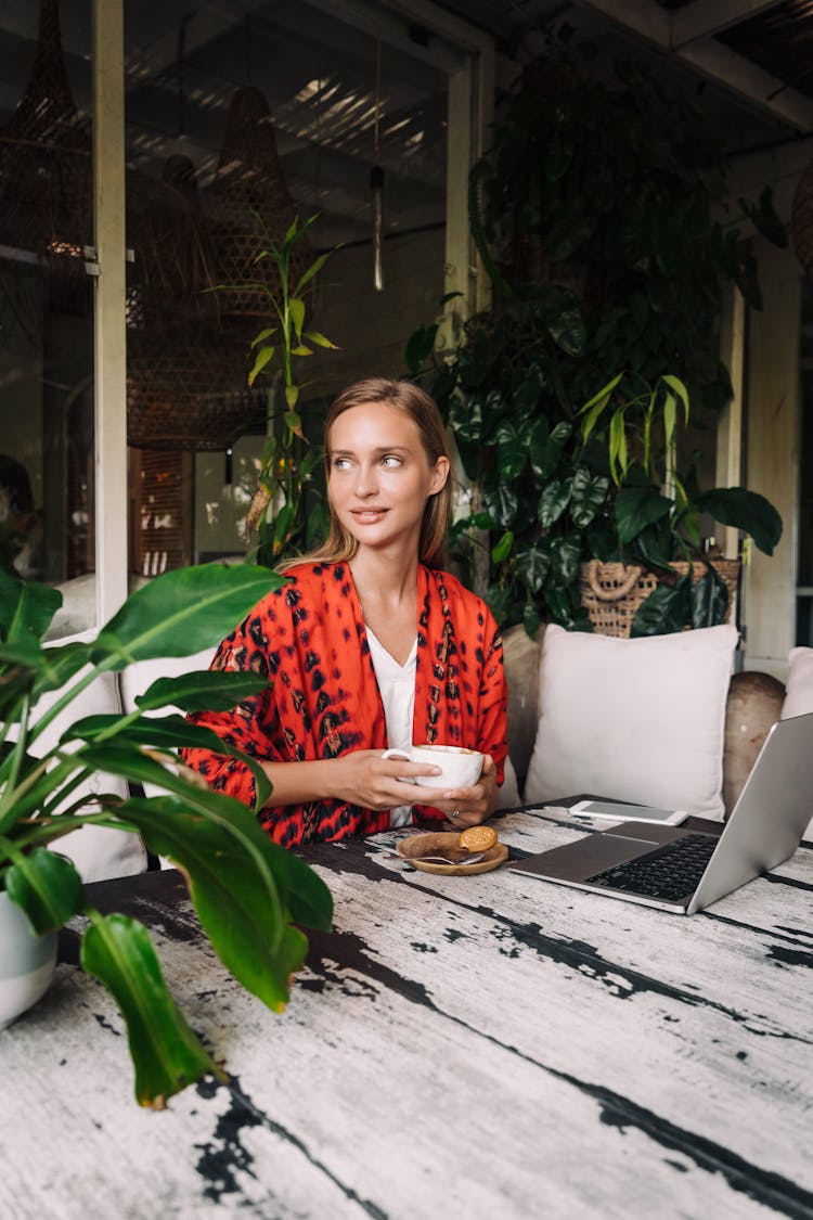 Woman Having Coffee Beside Her Laptop