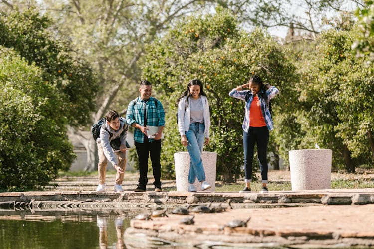 Friends Hanging Out Beside A Pond